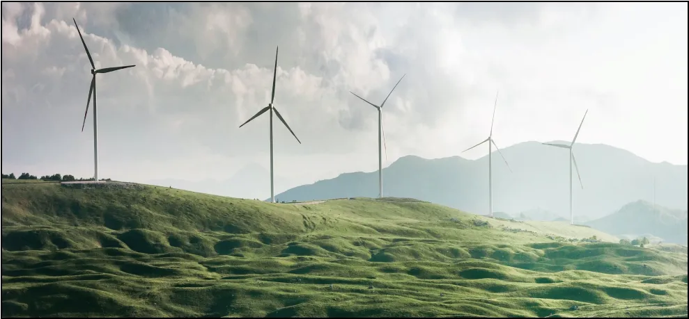 Wind turbines on green hills under a cloudy sky