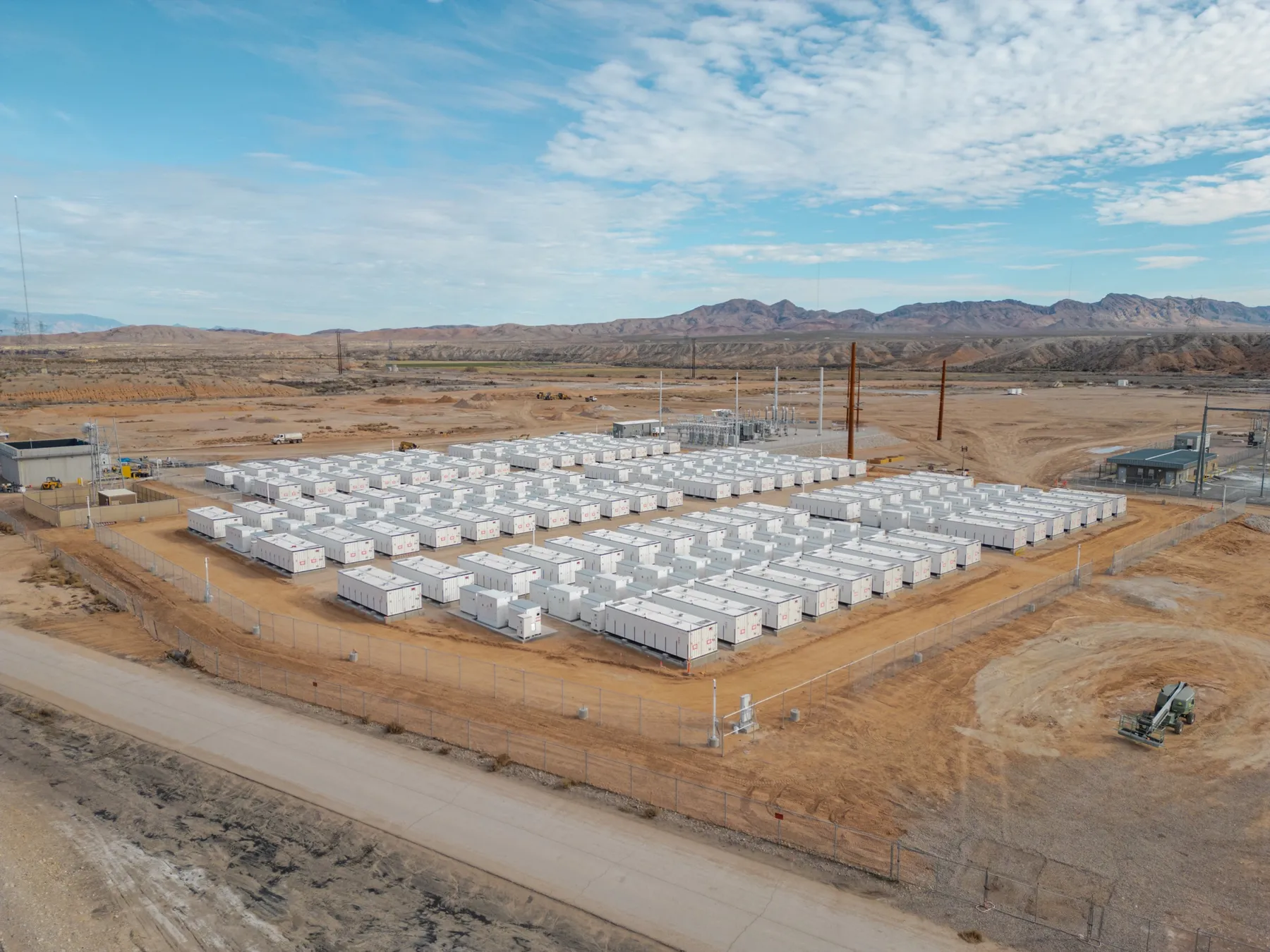 Rows of battery storage containers at a utility-scale BESS site