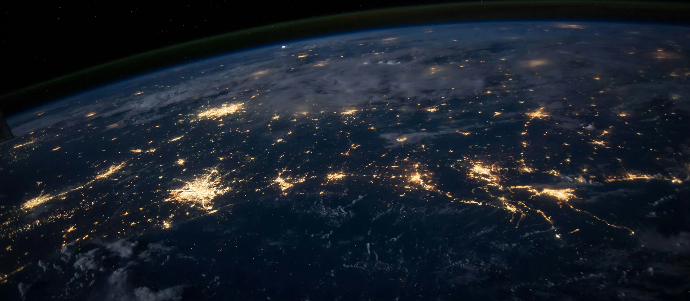 Earth at night with glowing city lights and network of connections (Unsplash)