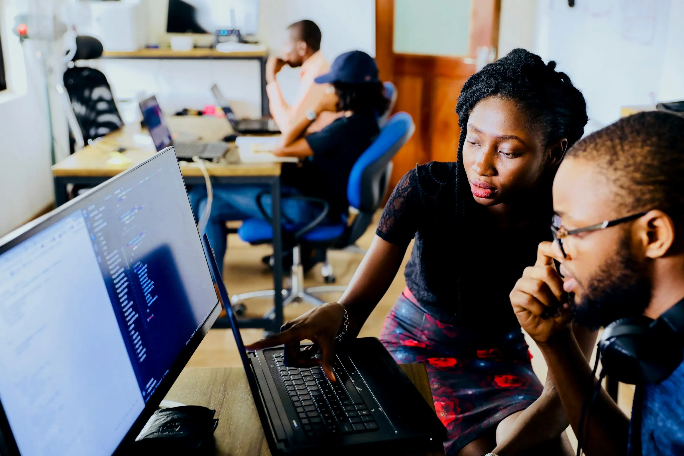 Two engineers reviewing code on a monitor in an office (Unsplash free license)