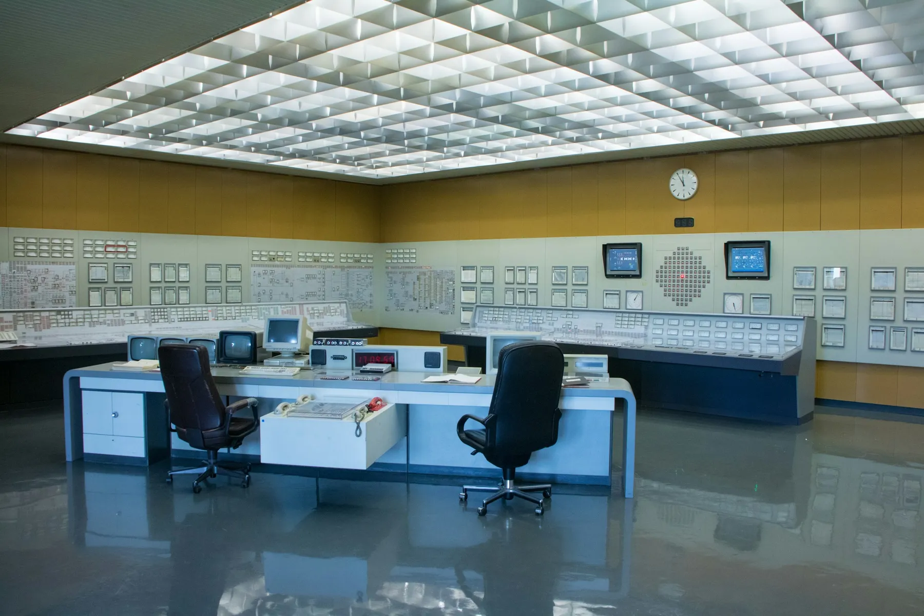 Industrial control room with operator desks and process control panels