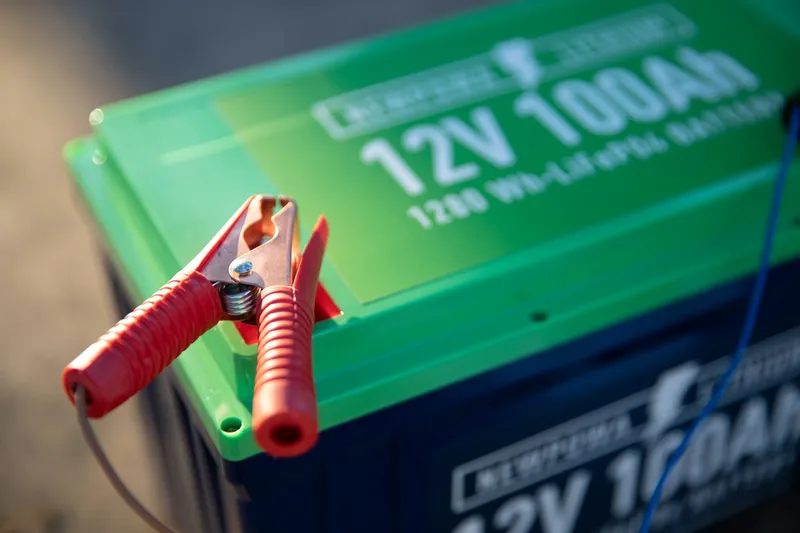 A lithium battery module being pulled from a storage rack - the kind of energy store a BMS keeps safe and balanced