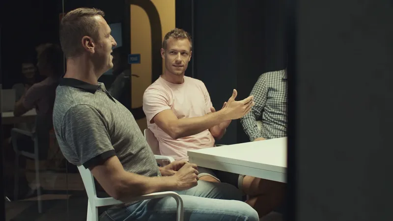 Two Order Group team members talking at a table during a meeting